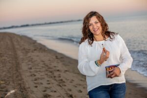 Cheri Arellano holding essential oils on the beach